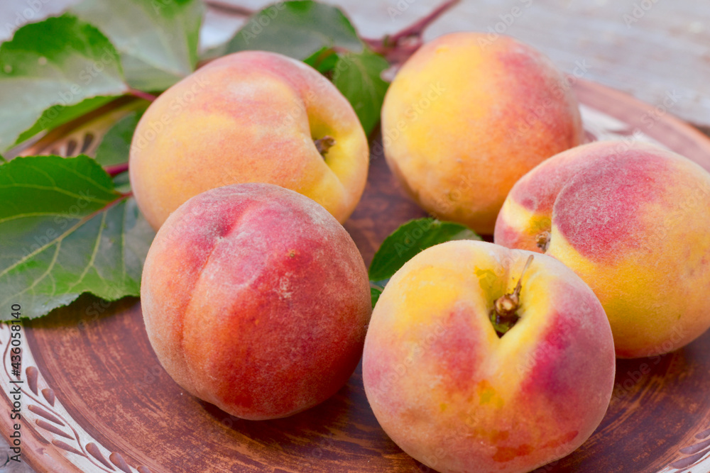 The picture shows ripe peaches on a plate close-up The picture shows ripe peaches on a plate close-up