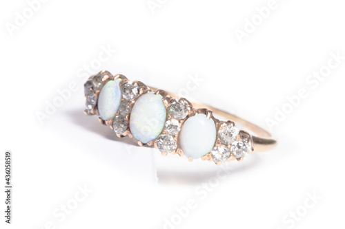 A diamond and opal ring on white