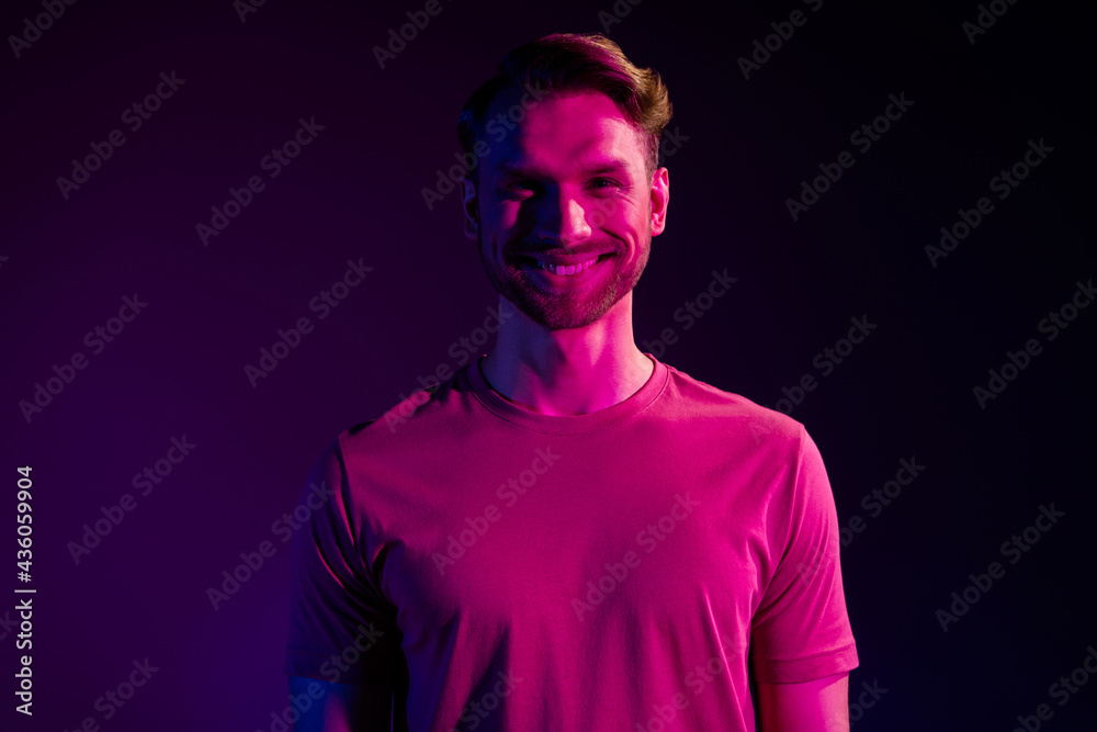 Portrait of attractive cheerful content guy at night club isolated over dark neon light violet color background Portrait of attractive cheerful content guy at night club isolated over dark neon light violet color background