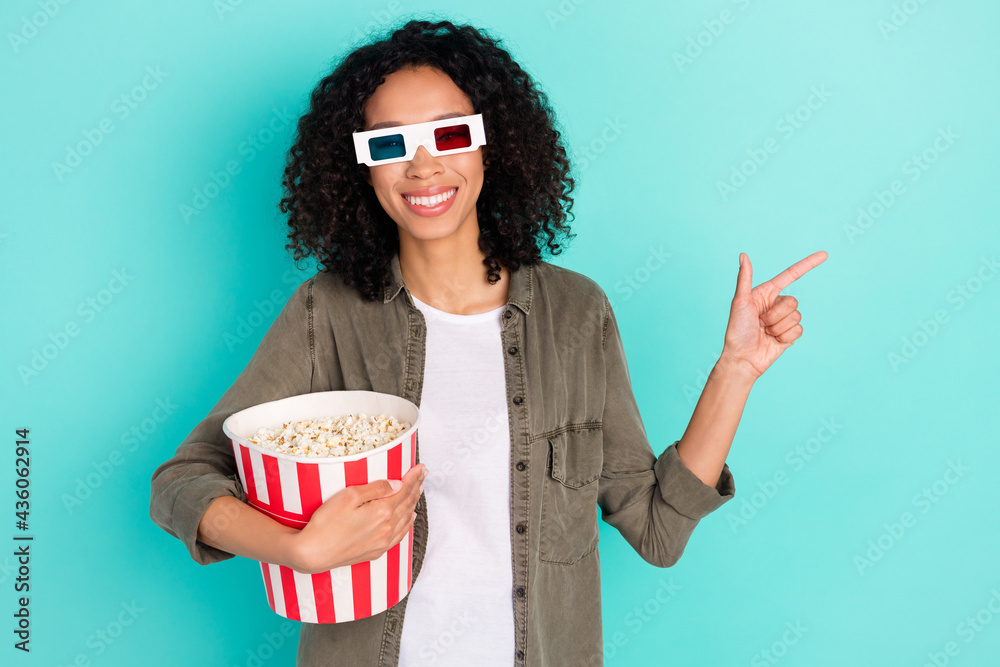 Portrait of beautiful trendy cheerful girl eating corn watching film demonstrating copy space isolated over bright blue color background Portrait of beautiful trendy cheerful girl eating corn watching film demonstrating copy space isolated over bright blue color background