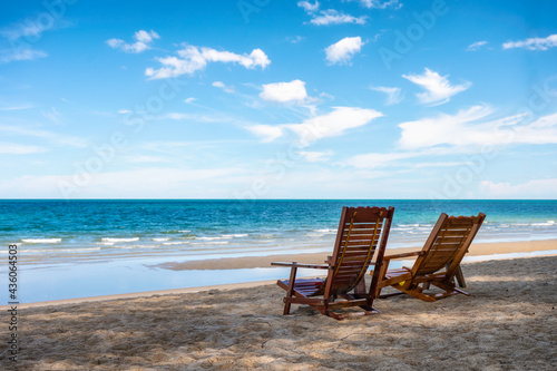 Empty two wooden chair on the beach in tropical sea on sunny