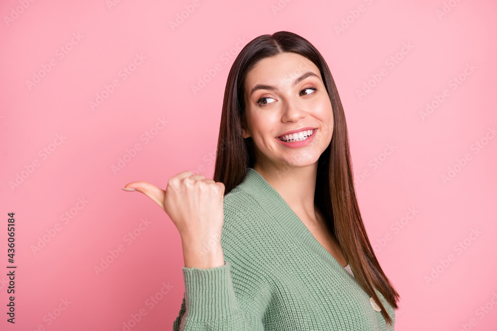 Profile photo of optimistic cool girl look point back empty space wear sweater isolated on pink color background Profile photo of optimistic cool girl look point back empty space wear sweater isolated on pink color background