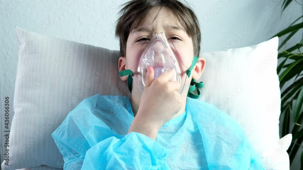 little patient in shirt, child, boy lies, facial oxygen mask, concept of medical care, anesthesiology and intensive care, oxygen therapy, treatment of coronavirus, COVID-19