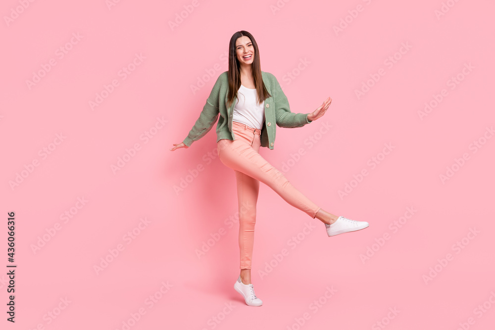 Full size photo of optimistic girl dancing wear sweater trousers sneakers isolated on pink color background Full size photo of optimistic girl dancing wear sweater trousers sneakers isolated on pink color background