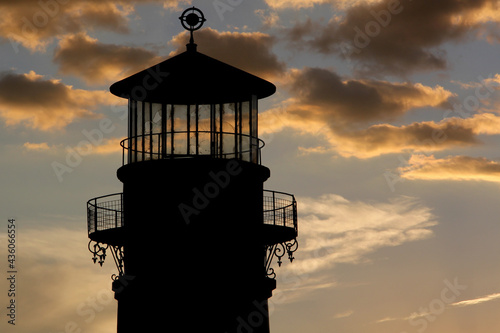 Silhouette of old lighthouse tower on a stunning sunset almost nightfall sky to look for seafood and navigation for boats and guidance of ships 