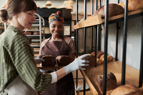 Two women in aprons baking homemade bread in bakery