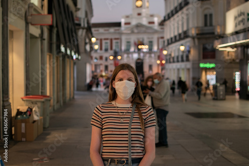 Prevention of coronavirus outbreak in 2020. Portrait of young european woman wearing a mask in the city street. Medical mask. FFP2 mask Prevent pollution and disease concept.