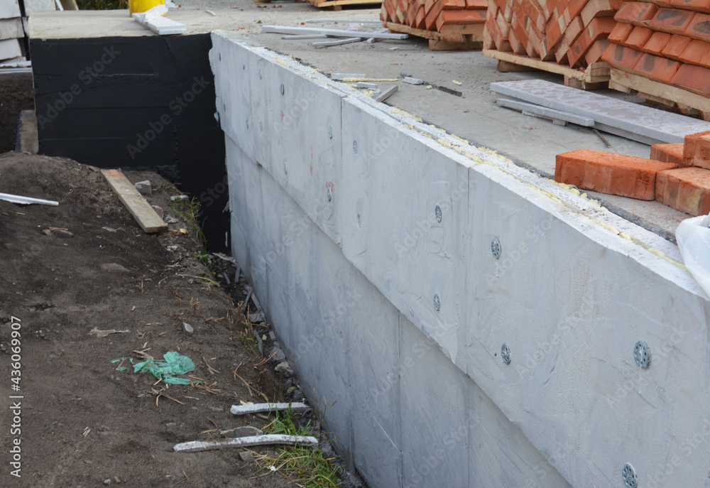 A closeup of an exterior house foundation, basement waterproofing and