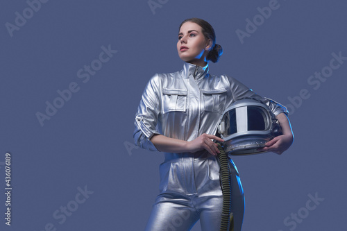Tableau sur toile Female space explorer in spacesuit holding helmet