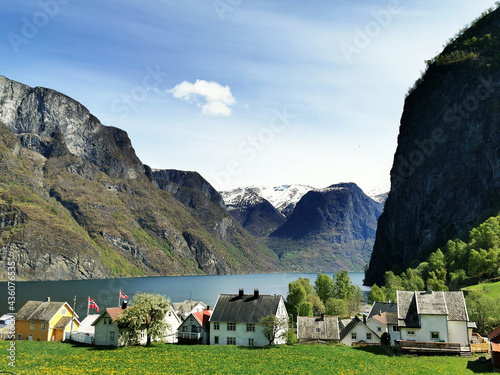 Village houses on the shore of a lake and mountains in the background in Undredal, Norway photo