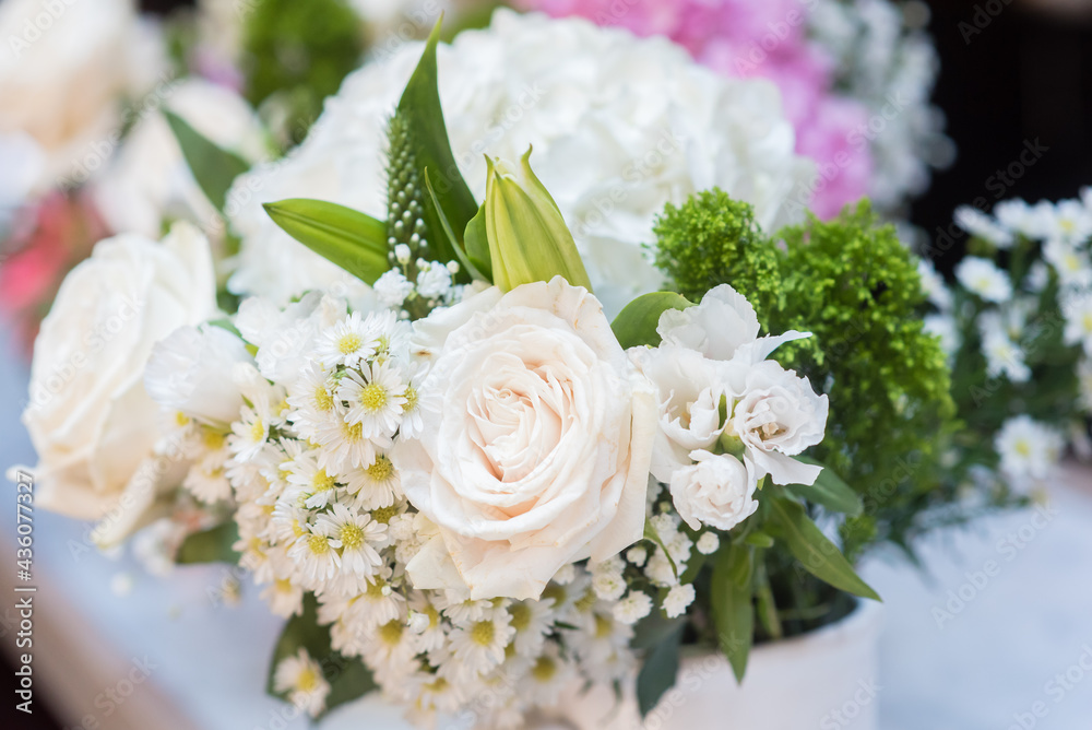 Bouquet of white roses with blurred background and green accents Bouquet of white roses with blurred background and green accents
