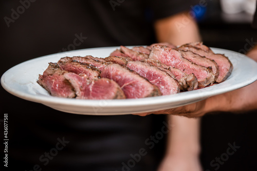 Rare slices of filet mignon on a plate. Close up with blurred background