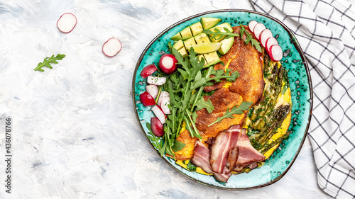 omelette with green vegetables asparagus, avocado, arugula, bacon ham and cheese. Keto breakfast. banner, menu recipe place for text, top view