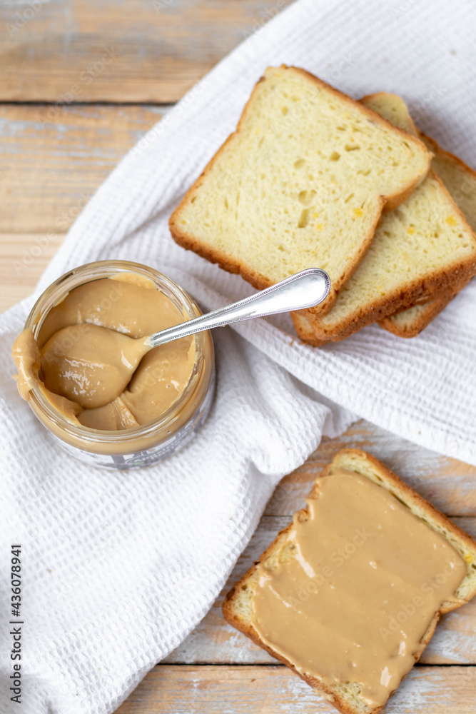 Peanut butter on white bread on wooden background. Flat lay Peanut butter on white bread on wooden background. Flat lay