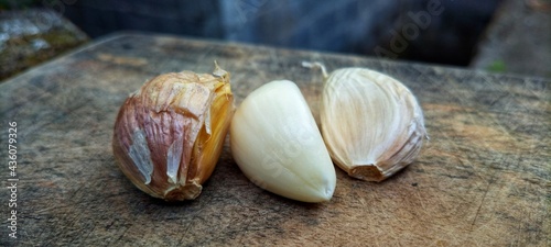 the garlic lies on a wooden table. Garlic on vintage wood background.