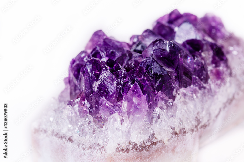 Macro mineral stone purple amethyst in crystals on a white background Macro mineral stone purple amethyst in crystals on a white background