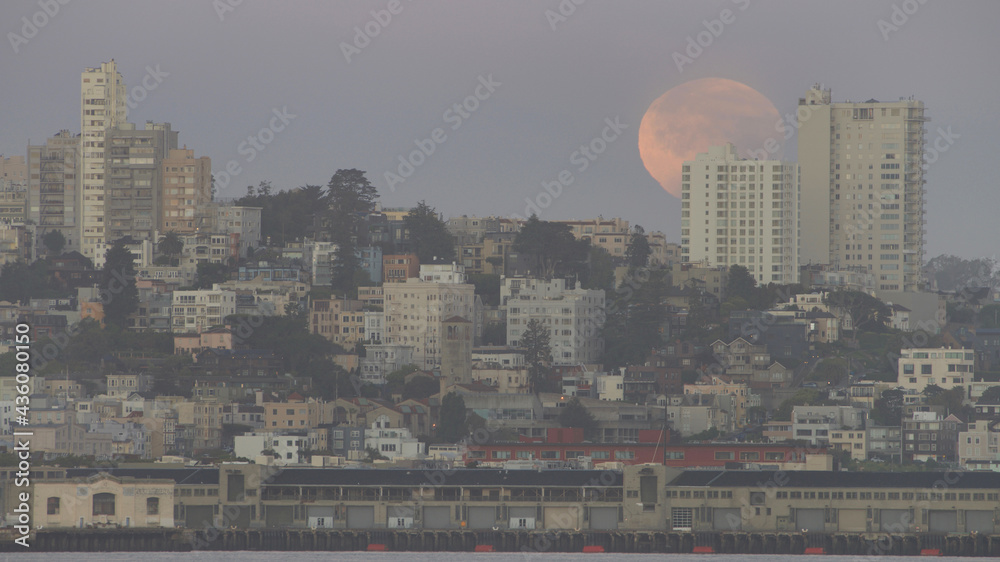 partial eclipse of full blood super moon setting over the outskirts of San Francisco, CA. in early hours of dawn
