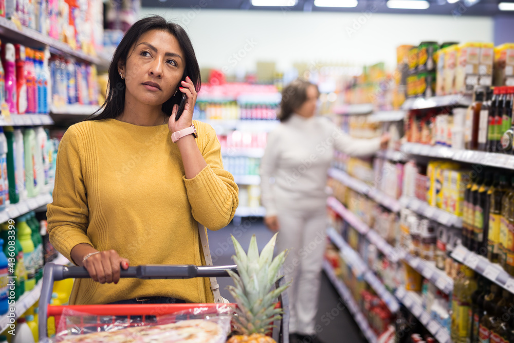 Woman talking on phone in a grocery supermarket