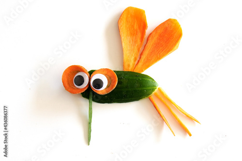 Food art creative concepts. Funny mosquito fly made of fruits and vegetables, such as carrots and cucumber isolated on a white background.