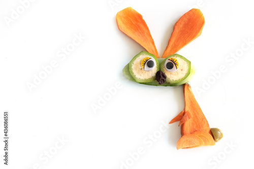 Food art creative concepts. Funny bunny rabbit made of fruits and vegetables, such as carrots and cucumber isolated on a white background.