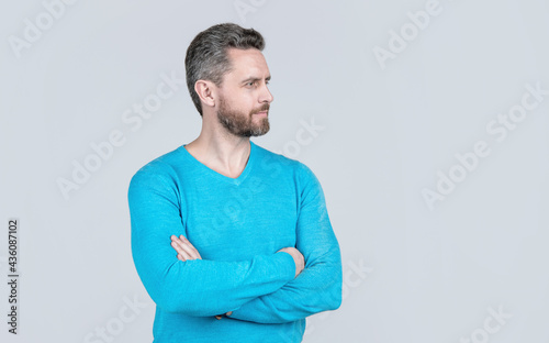 handsome mature man with beard on grey background, fashion model