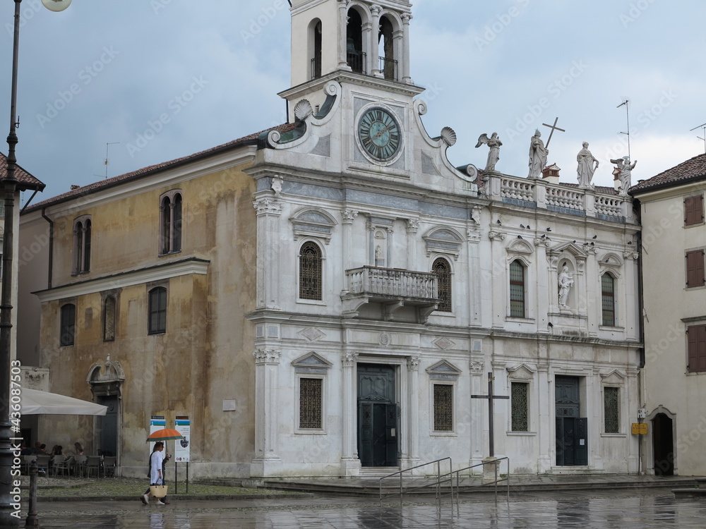 Udine Street View with White Old Church Facade and Walking Couple with Umbrella