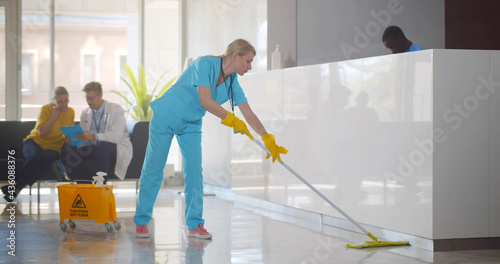 Young female nurse cleaning floor in hospital reception area © TommyStockProject