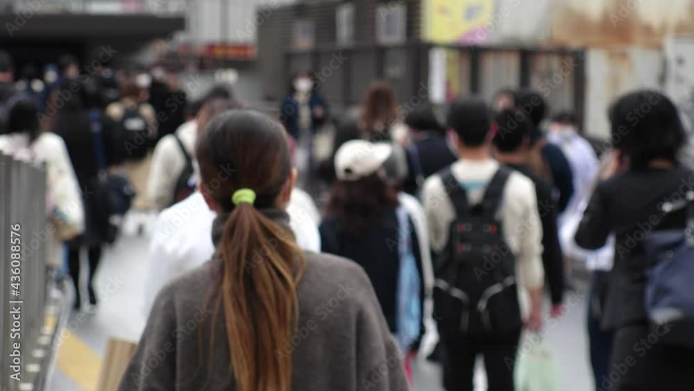 OSAKA, JAPAN - APRIL 2021 : Crowd of people wearing surgical masks to protect from Coronavirus (COVID-19) at the street in busy rush hour. View of commuters after work around Osaka train station. OSAKA, JAPAN - APRIL 2021 : Crowd of people wearing surgical masks to protect from Coronavirus (COVID-19) at the street in busy rush hour. View of commuters after work around Osaka train station.