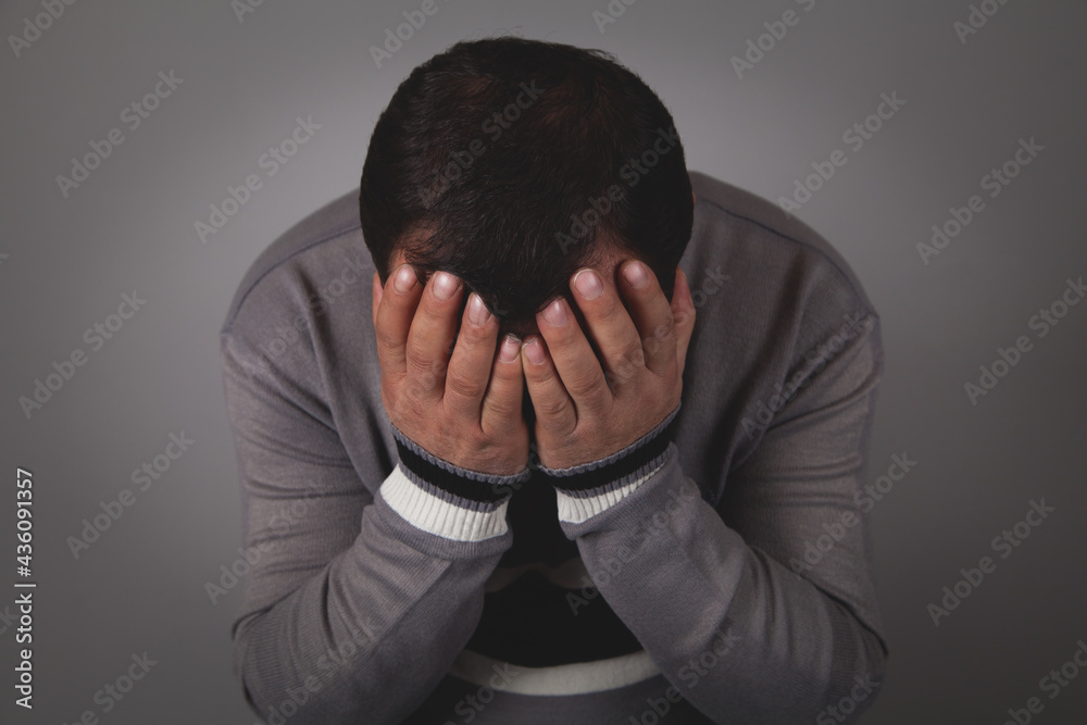 Sad man hands on face, gray background. Sad man hands on face, gray background.