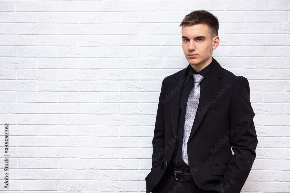 Male businessman on a white brick wall background Male businessman on a white brick wall background