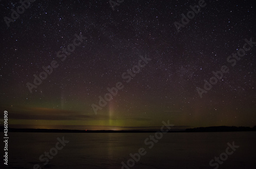 Northern lights aurora borealis over pond in Latvia.