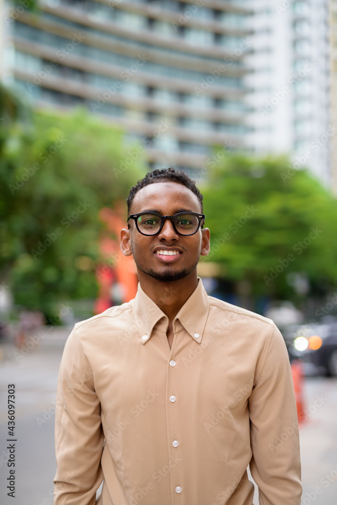 African businessman outdoors in city smiling and looking at camera African businessman outdoors in city smiling and looking at camera