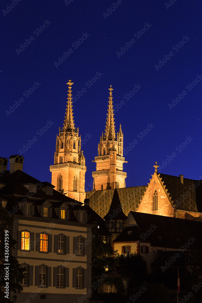 The twin tower of the Basel cathedral under the blue night sky