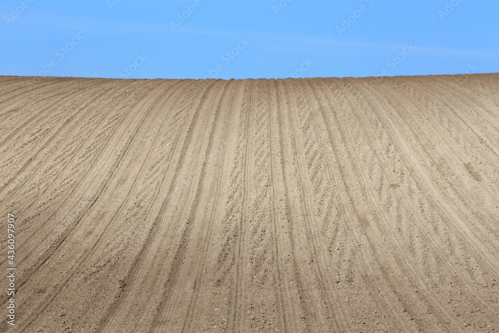 Naklejka premium Landscape agricultural land in slope recently plowed for the crop