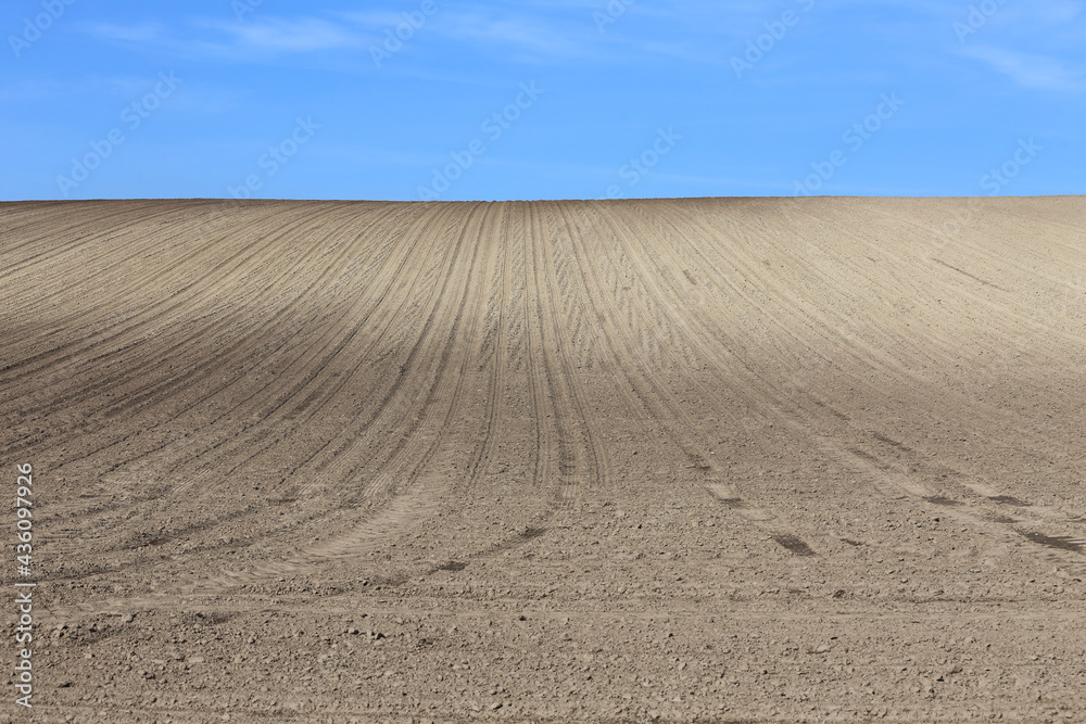 Naklejka premium Landscape agricultural land in slope recently plowed for the crop