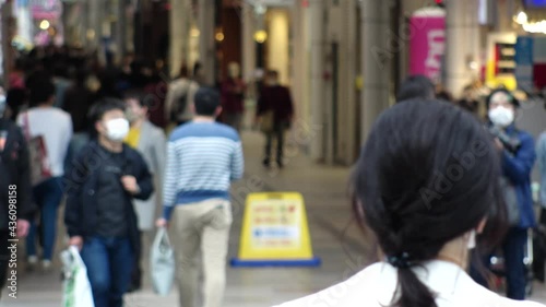 Wallpaper Mural OSAKA, JAPAN - APRIL 2021 : Crowd of unidentified people wearing surgical masks to protect from Coronavirus (COVID-19) at busy downtown street. Slow motion shot. Focus in front. Torontodigital.ca