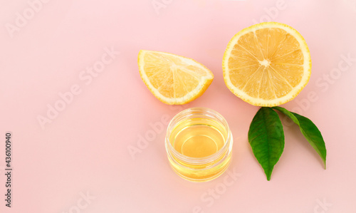 Lemon slices and cosmetic lemon oil on a pink background. Close up,space for text