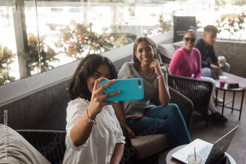 Grupo de amigas tomando una selfie sentados, celular en primer plano