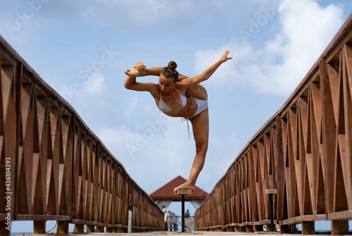 Schilderij op canvas Flexible female circus Artist keep balance in split on the bridge