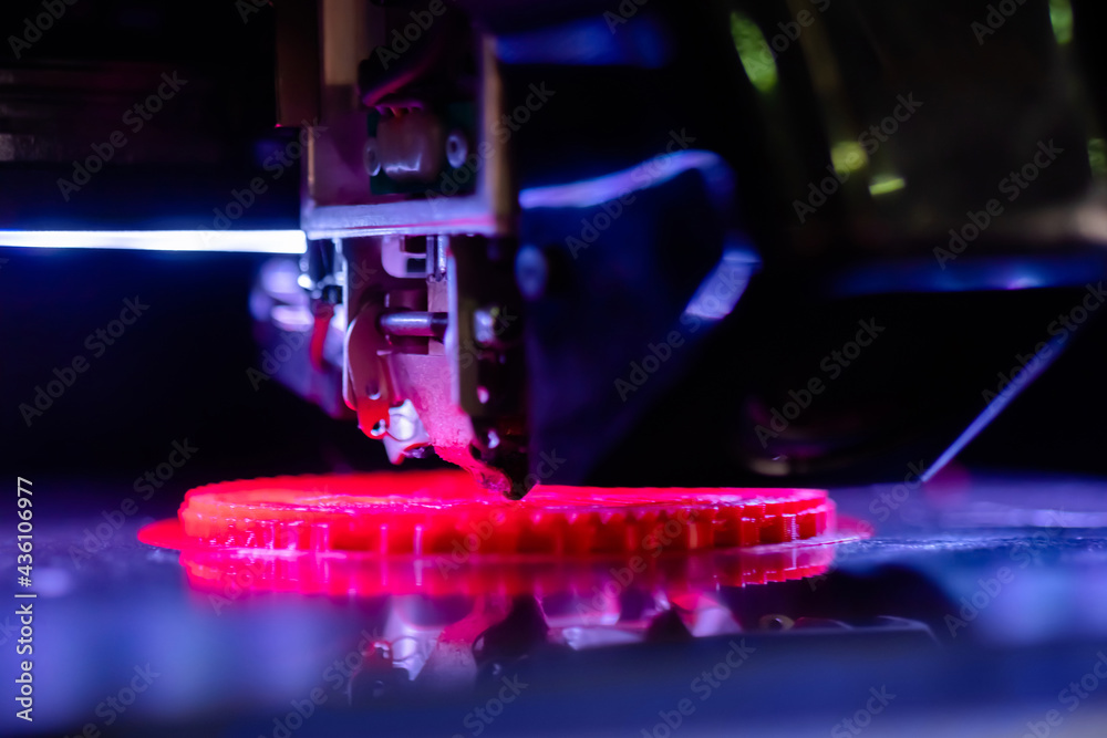 Print head of three dimensional printer machine printing flat red plastic model at modern exhibition - close up. 3D printing, additive technology, equipment, manufacturing and futuristic concept Print head of three dimensional printer machine printing flat red plastic model at modern exhibition - close up. 3D printing, additive technology, equipment, manufacturing and futuristic concept