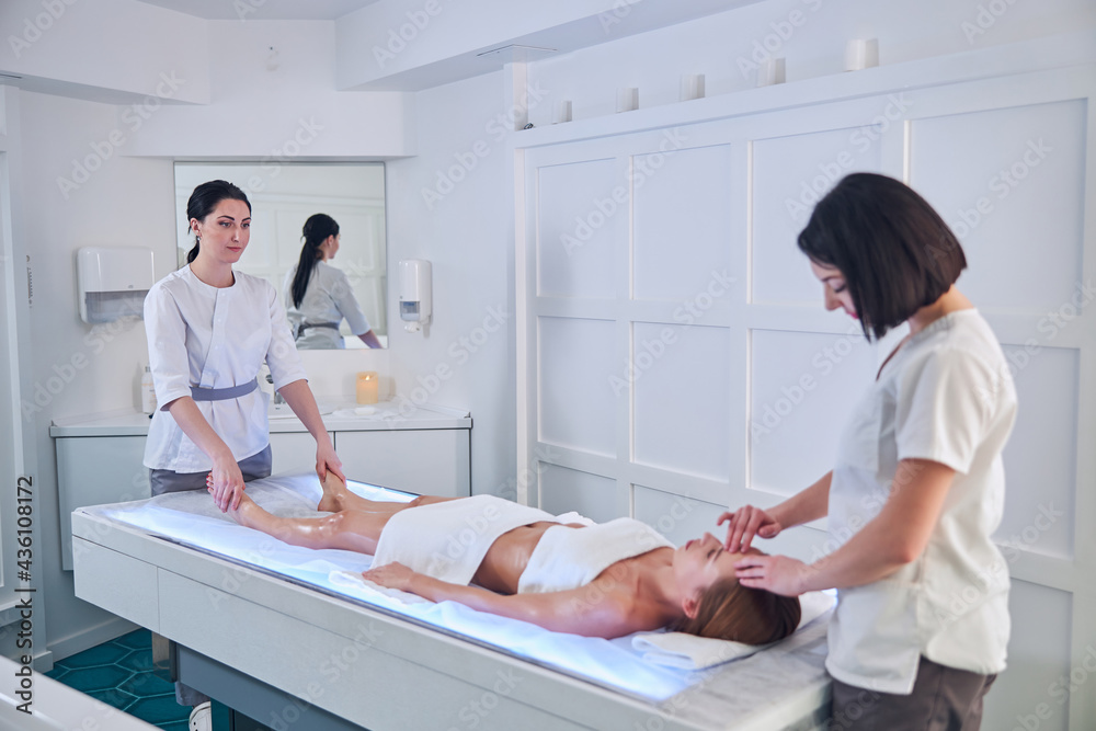 Image of professional two masseurs making spa treatment in spa salon Image of professional two masseurs making spa treatment in spa salon