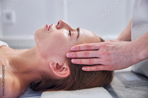 Adorable Caucasian lady receiving professional care and resting in spa resort center