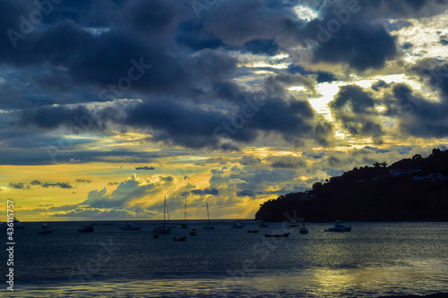 A sunset off the coast of Nicaragua with boats arriving