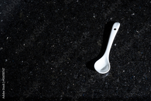 A white ceramic spoon to decorate a dinner plate or take pictures.