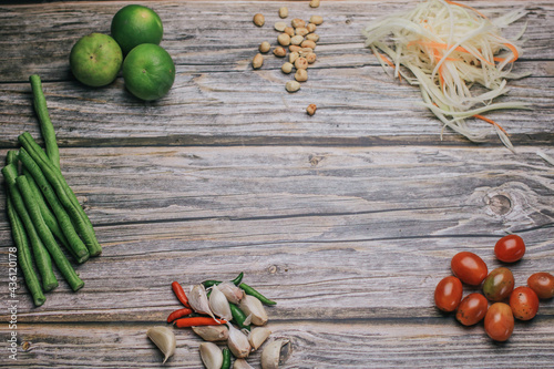 Papaya salad (Som Tam) ingredients on wooden table background.The famous local Thai street food dish with the taste of hot and spicy.