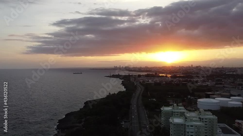 Hermoso atardecer tomado en la avenida España, en republica dominicana, con una victa al mar donde se aprecia un barco a lo lejos photo