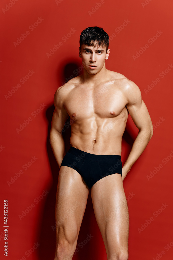 athletic guy in black panties nude torso bodybuilder Fitness red background 