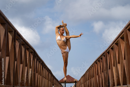 Flexible female circus Artist keep balance in split on the bridge. Motivation, passion and achievement concept 