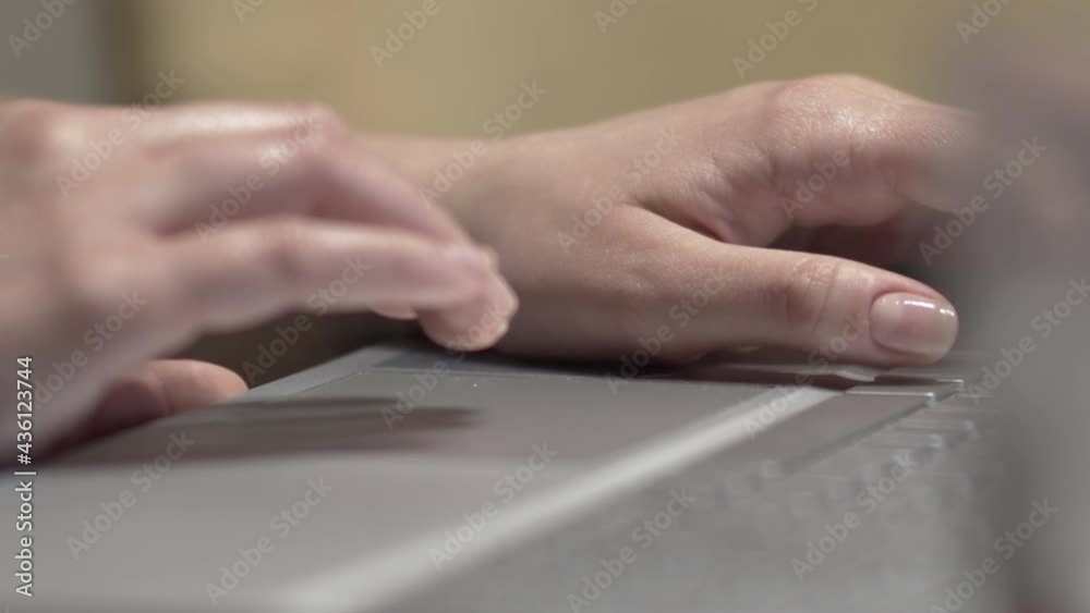 Close-up of female's hand touching the touchpad on a laptop computer in work place Close-up of female's hand touching the touchpad on a laptop computer in work place