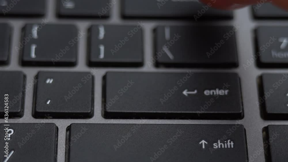 Enter button pressing on keyboard, laptop keyboard close up